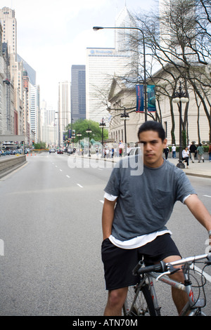 Maschio ispanica sulla sua bicicletta su Michigan Avenue, vicino all'Istituto d'Arte di Chicago, Illinois Foto Stock