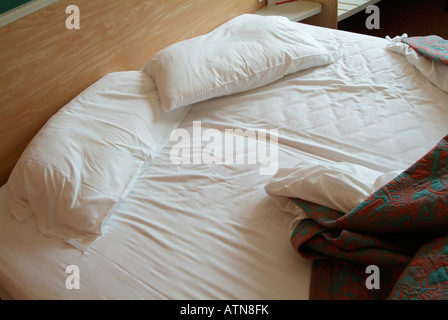 Letto disfatto in un hotel Foto Stock