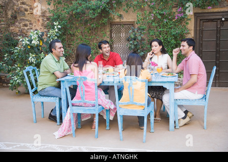 Gruppo di persone sedute a un tavolo da pranzo Foto Stock