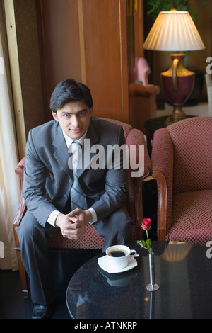 Ritratto di un imprenditore seduto in poltrona e smirking Foto Stock