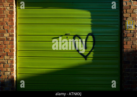 Amore spruzzi di cuore dipinta su un garage verde Foto Stock