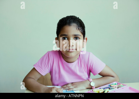 Ritratto di una scolaretta seduti ad un tavolo e Disegno con matite colorate Foto Stock