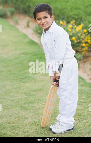 Ragazzo tenendo un cricket bat Foto Stock
