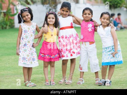 Ritratto di cinque ragazze in piedi insieme in un prato e sorridente Foto Stock