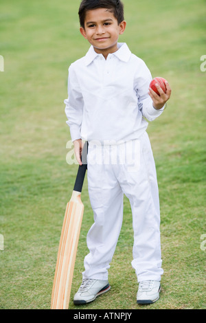 Ragazzo tenendo un cricket bat e una sfera di cricket Foto Stock