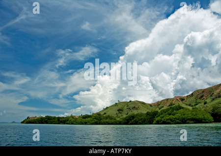 Cielo blu, il bianco delle nuvole e isola verde Foto Stock