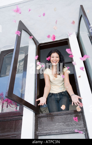 Basso angolo vista di una giovane donna di gettare i fiori Foto Stock