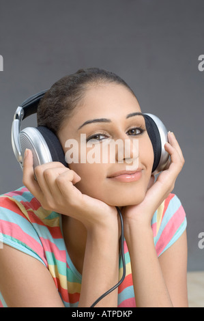 Ritratto di una giovane donna di ascolto di musica e smirking Foto Stock