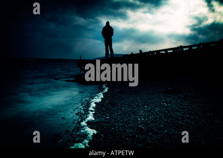 Uomo in piedi su un molo al chesil beach dorset Foto Stock