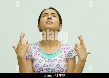 Close-up di una giovane donna con le dita incrociate Foto Stock