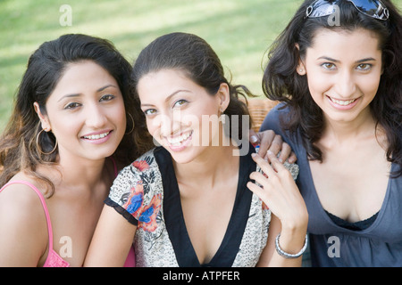 Ritratto di tre giovani donne seduti insieme e sorridente Foto Stock