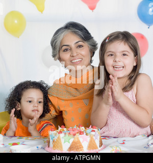Ritratto di una donna matura per celebrare il suo compleanno con i suoi due nipoti Foto Stock
