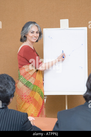 Ritratto di una imprenditrice dando la presentazione in una riunione e sorridente Foto Stock