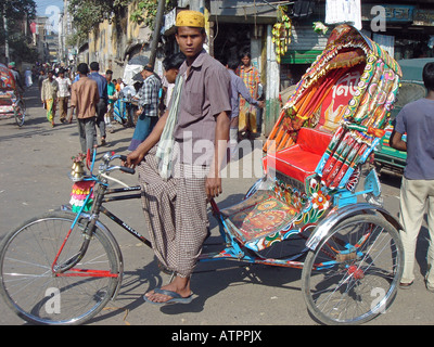 Un wallah in risciò del Bangladesh su una strada trafficata nella capitale Dhaka, Bangladesh Foto Stock