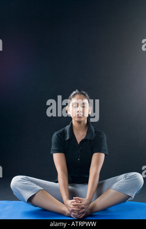 Giovane donna meditando con gli occhi chiusi Foto Stock
