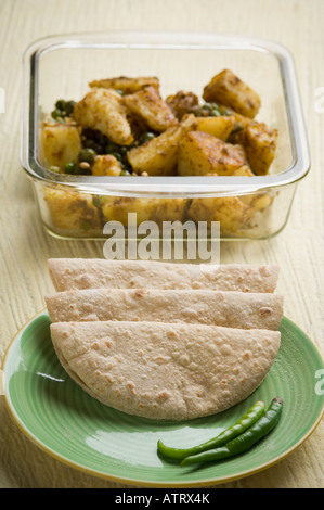 Close-up di chapattis in una piastra con una ciotola di patate sabzi Foto Stock