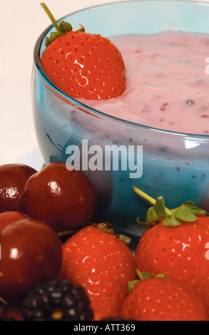 Primo piano di yogurt alla fragola in un recipiente di vetro e frutta fresca Foto Stock