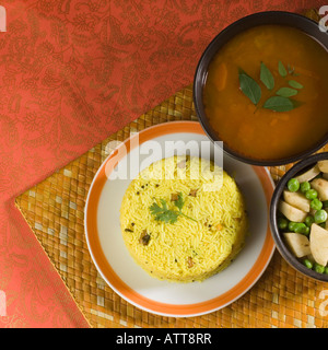 Angolo di alta vista di riso in una piastra con daal e fritto di piselli e patate a fette in una ciotola Foto Stock