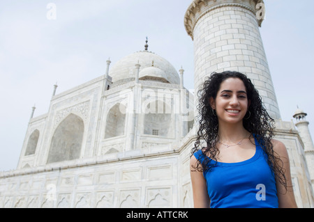 Ritratto di una giovane donna in piedi di fronte a un mausoleo, Taj Mahal, Agra, Uttar Pradesh, India Foto Stock