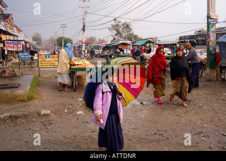 Una giovane ragazza con un colorato ombrellone sulla strada in Nepal. Foto Stock