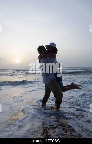 Silhouette di una giovane coppia romancing sulla spiaggia, Goa, India Foto Stock