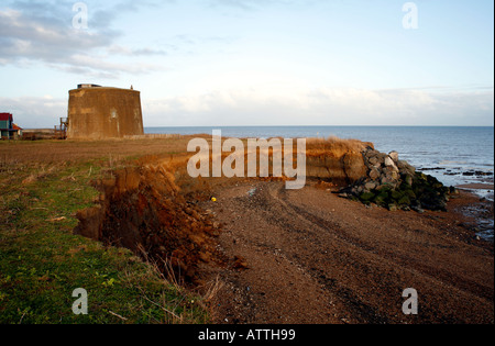 Martello Tower e casa a Oriente Bawdsey Suffolk in Inghilterra nel pericolo di scivolare nel mare del nord a causa di erosione costiera Foto Stock