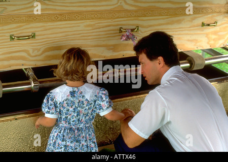 Padre e figlia età 35 e 5 a grave guardando dalle due nonne fatti a mano bara di legno compensato. Cambria Wisconsin USA Foto Stock