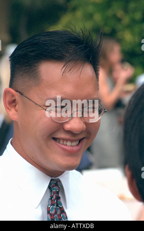 Uomo asiatico età 25 cercando felice e ridere. Ospiti di nozze San Francisco California USA Foto Stock
