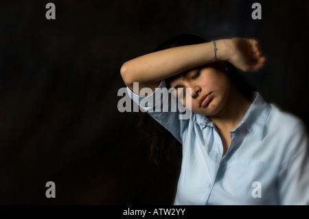 Stanco giovane donna mano sulla testa Foto Stock