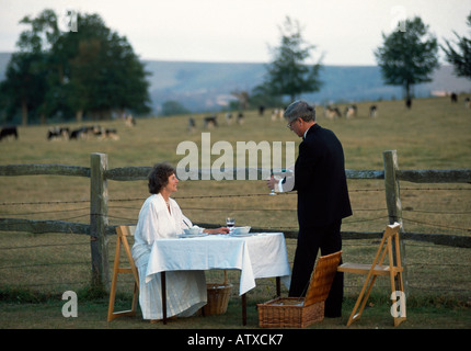 A couple picnic in the grounds during the interval at the famous Glyndebourne Opera in Sussex England Foto Stock