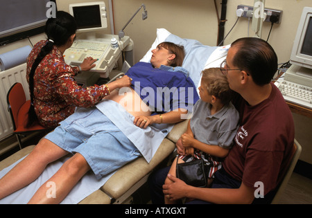 Medico di eseguire una scansione ad ultrasuoni su una donna in stato di gravidanza Foto Stock