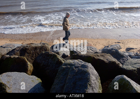 Frinton on sea beach a bassa marea con un maschio solitario walker Foto Stock