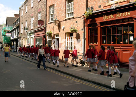 Un gruppo di studentesse camminando lungo la High Petergate probabilmente su una gita scolastica a York Foto Stock