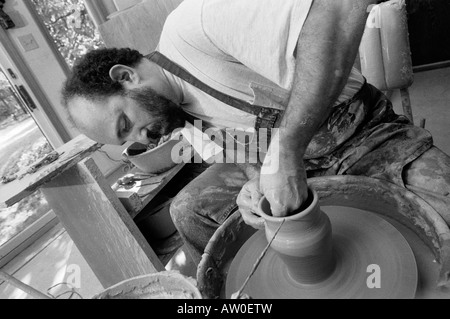 Un vasaio opere gettando vasi di ceramica nel suo studio di produzione quasi perfetta di duplicati di uno dei suoi disegni. Vetri seguiranno. Foto Stock