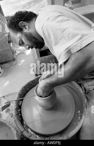 Un vasaio opere gettando vasi di ceramica nel suo studio di produzione quasi perfetta di duplicati di uno dei suoi disegni. Vetri seguiranno. Foto Stock