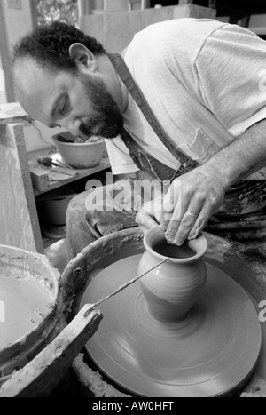 Un vasaio opere gettando vasi di ceramica nel suo studio di produzione quasi perfetta di duplicati di uno dei suoi disegni. Vetri seguiranno. Foto Stock