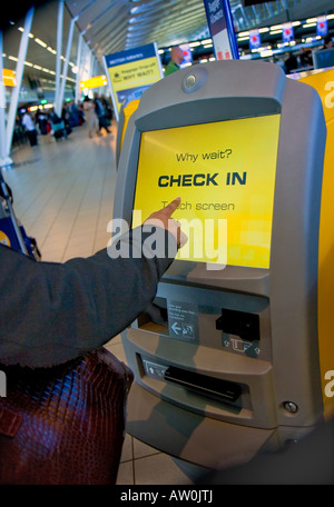 Donna che utilizza il controllo automatico in Terminale con schermo sensibile al tocco sul Aeroporto Schiphol, Paesi Bassi Foto Stock