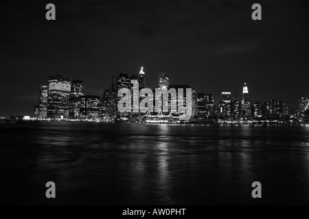 Un tempo di notte vista di Manhattan inferiore attraverso l'East River da Brooklyn. Foto Stock