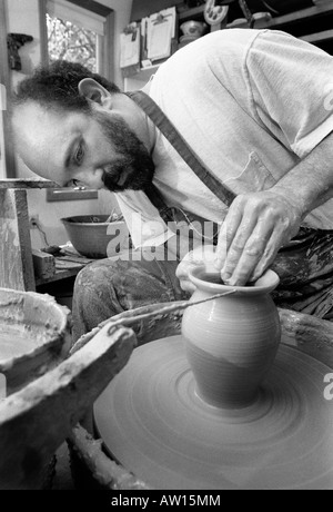 Un vasaio opere gettando vasi di ceramica nel suo studio di produzione quasi perfetta di duplicati di uno dei suoi disegni. Vetri seguiranno. Foto Stock