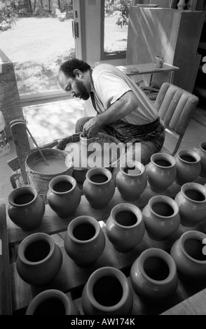 Un vasaio opere gettando vasi di ceramica nel suo studio di produzione quasi perfetta di duplicati di uno dei suoi disegni. Vetri seguiranno. Foto Stock