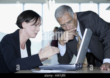 Uomo di affari e business donna per discutere le modifiche su un notebook Foto Stock