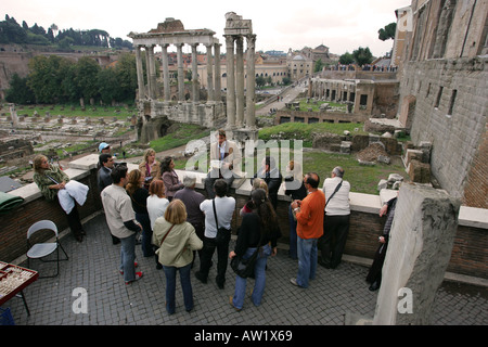 Ben vestito tour italiano guida spiega la storia del Foro Romano per un gruppo di turisti europei visitatori Roma Italia EU Foto Stock