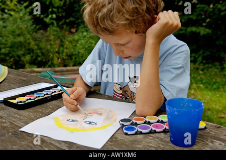 Nove-anno-vecchio ragazzo dipingere un quadro con i colori di acqua Foto Stock