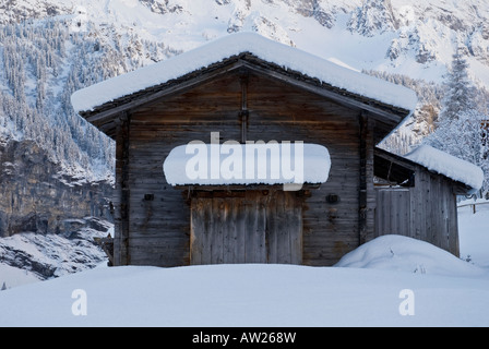 Fienile in legno coperto di neve fresca in Swiss Mountain Village di Gimmelwald, Oberland bernese, Svizzera Foto Stock