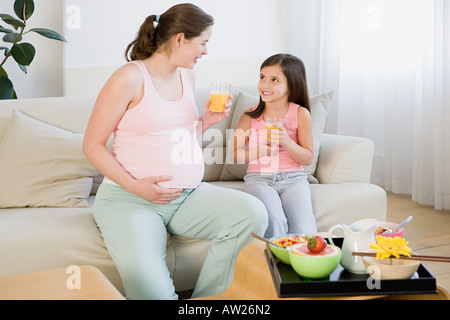 Madre e figlia holding bicchieri di succo di arancia Foto Stock