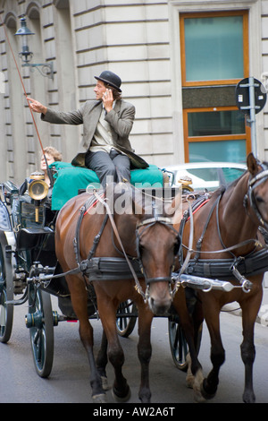 Carro trainato da cavalli con driver Fiaker a parlare su un telefono mobile a Vienna Austria Foto Stock