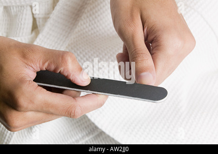 L'uomo deposito le sue unghie Foto Stock