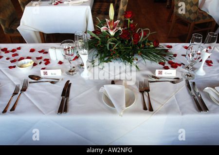 Inserire le impostazioni per la sposa e lo sposo nella parte superiore tavola di un ricevimento di nozze Foto Stock