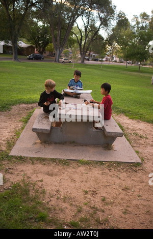 Tre ragazzi giocare Yugioh trading card game al parco pubblico, Sudovest degli Stati Uniti Foto Stock