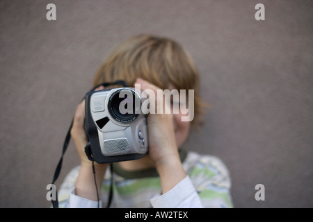 Bambino di otto anni le riprese con una videocamera all'aperto Foto Stock